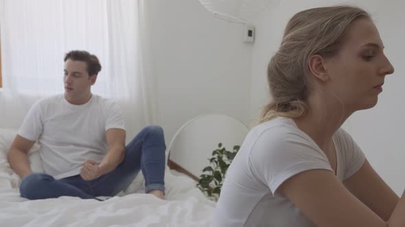 Depressed woman sitting on the bed after argument with her boyfriend