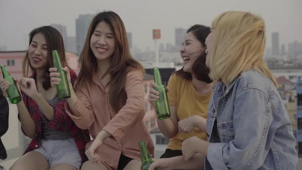 Group of young asian dancing and raising their arms up  the music at sunset urban party on rooftop. alt