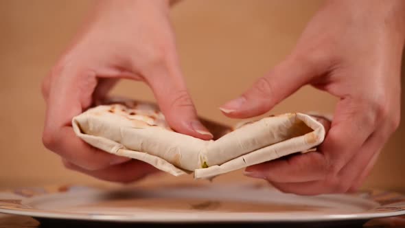 the girl picks up a homemade pie and breaks it into two halves. alt