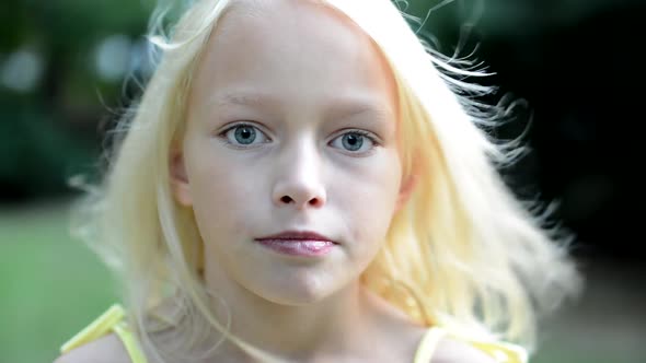 Little Cute Girl Look Seriously in the Camera - Eye Contact - Wind Blows Her Hair alt