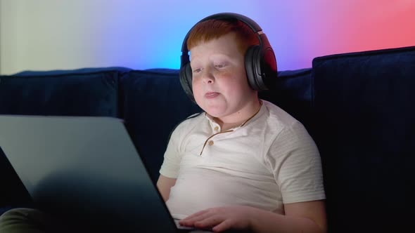 A Boy Gets Online Education at Home in a Cozy Room with Warm and Neon Light alt