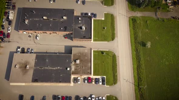 Drone flying over busy parking lots in a massive industrial complex. alt