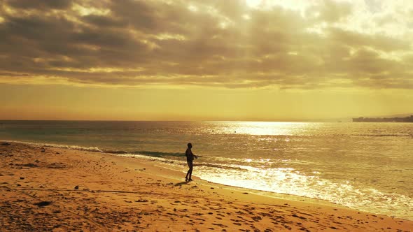 Angling for Happy man on holiday enjoying activities at beach on summer white sand and blue 4K backg alt