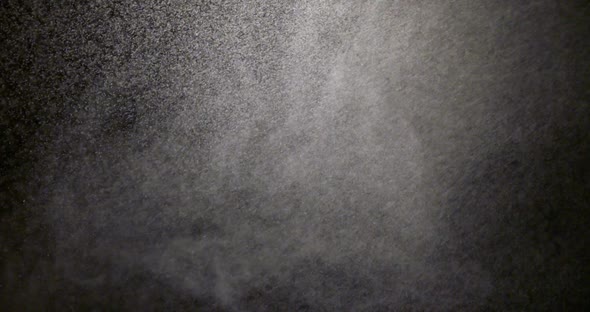 Water spray dust. Spraying mist effect of air gun isolated on black background. Slow motion