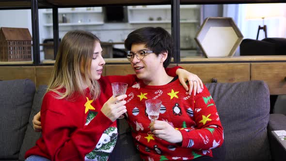 Happy Couple with Laptop Together on Sofa, Smiling Young Girl and Guy Having Fun Talking at Home alt