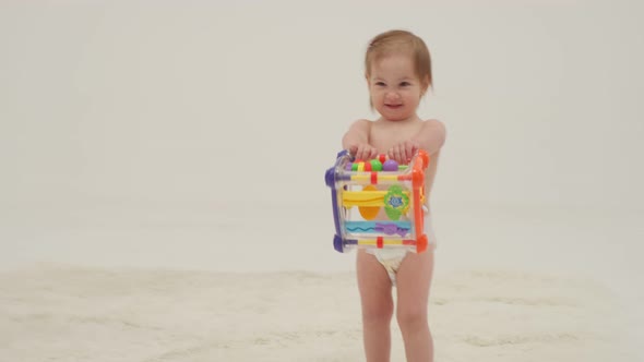 Happy Little Girl in Diaper is Playing Toys alt