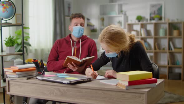 Young Tutor Man is Studying with a Young Woman at Her Home During Quarantine alt
