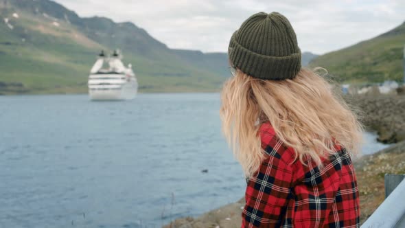 Young Woman Sits in Port Watch Cruise Ship Leave alt
