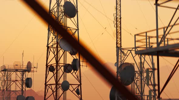 Antennas complex on a forested hills. Radio masts for telecommunication. Sunset. alt