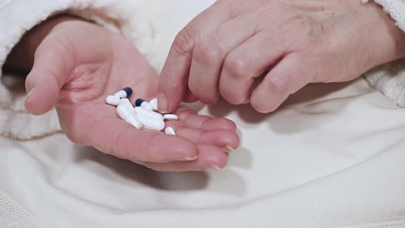 Elderly Woman Taking Medicines, Picking Pills From Hand, Closeup View. alt