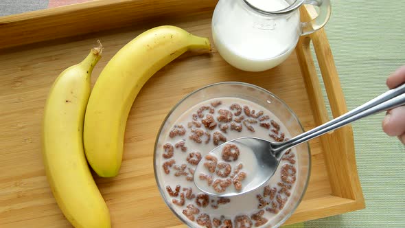 HD video, chocolate cornflakes in the form of an alphabet with milk in a bowl. Top view of a breakfa