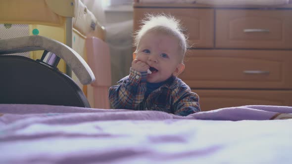Funny Boy in Warm Shirt Plays with Plastic Tube at Bed alt