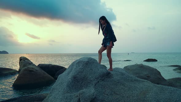 Cute Asian Girl Walking on a Rock at Beautiful Sunset in Slow Motion Thailand