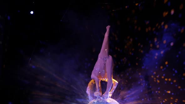 The Gymnast Performs an Acrobatic Number on a Mirror Ball