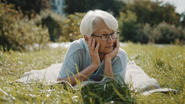 Senior Retired Woman Enjoying the Sunny Autumn Day in the Park alt