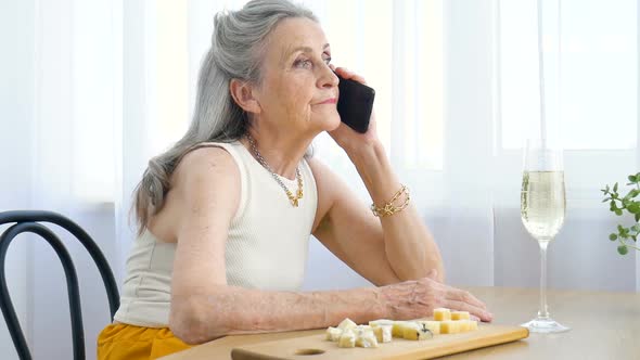 Beautiful Old Grandmother with Grey Hair and Face with Wrinkles is Using Smartphone Talking with alt