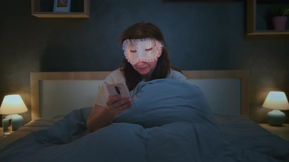 Night Zombie Woke Up at Night From a Message on the Phone Woman in a Night Mask Reads a Message on alt