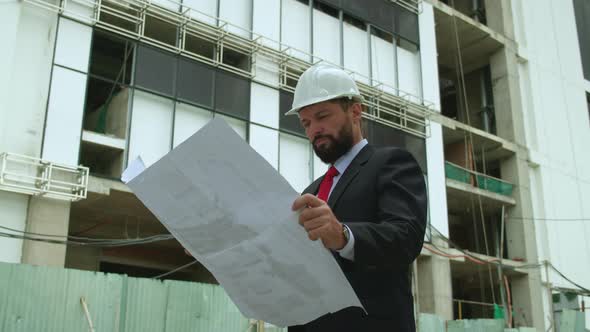 An Engineer Developer at a Construction Site Checks on the Drawings at What Stage the Construction alt