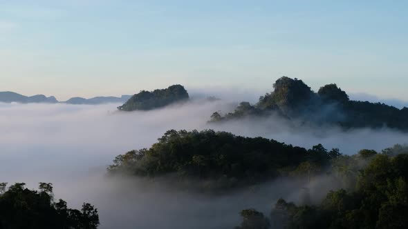 Landscape image of greenery rainforest mountains and hills with the sea of fog