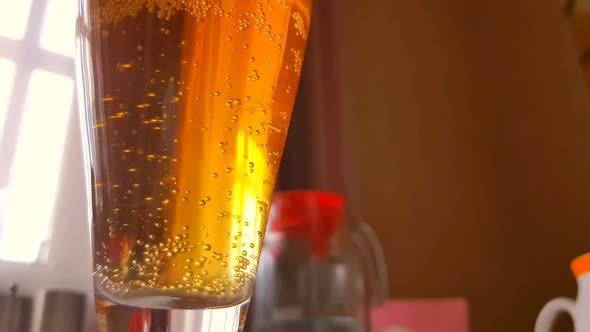 Close-up of a beer glass with bubbles rising up, 4K video