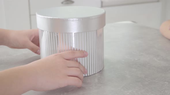 Camera Following Grey Gift Box Given By Male Little Hands To Caucasian Girl. Female Arms Spinning alt