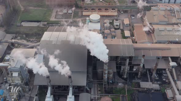 Aerial view Drone shot of flying around toxic chimneys tubing. Air Pollutants, Industrial zone.