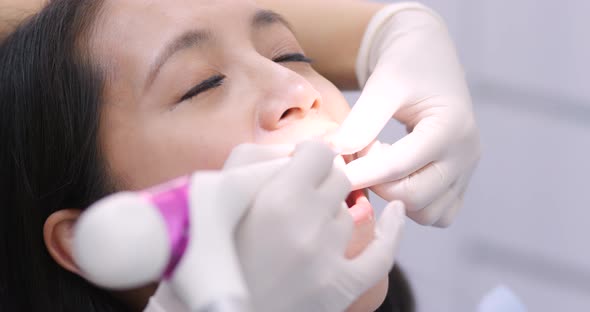 Woman dentist working at her patients teeth alt