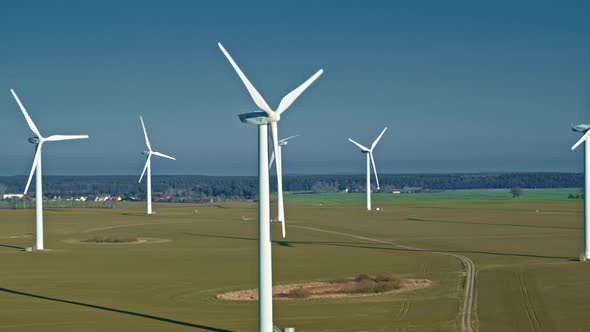 Aerial view of wind farm in the field on beautiful blue sky. alt