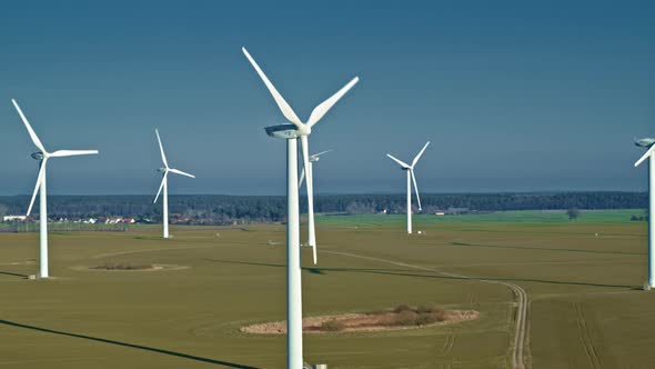 Aerial view of wind farm in the field on beautiful blue sky.