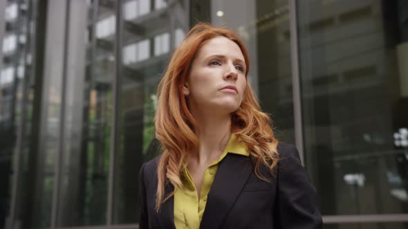 Businesswoman in city using smart phone with takeaway coffee