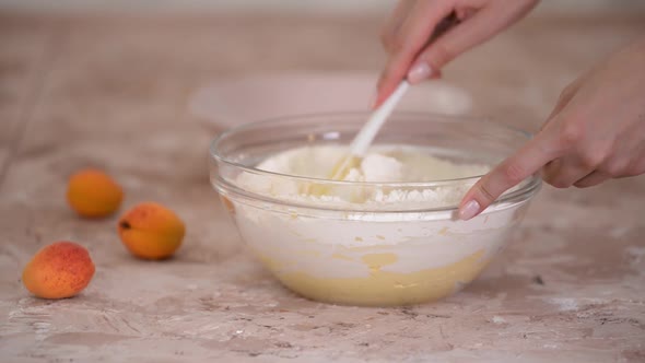 Hands Kneading Cake Dough in a Bowl Using a Spatula