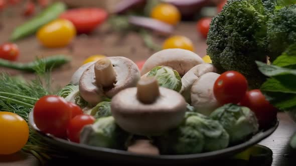 Plate with Mushrooms Vegetables and Greens on the Table alt