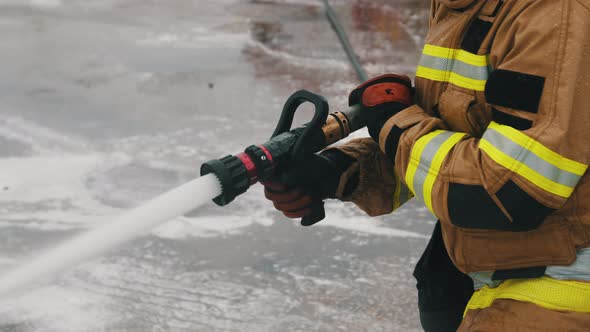 Close Up, Firefigter Extinguish Fire with the Hose alt