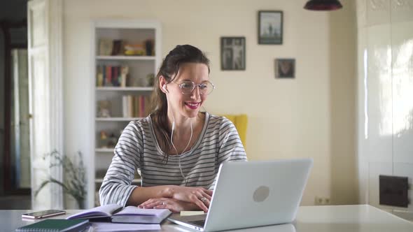 Beautiful Young Woman Having Video Conversation and Using Laptop at Table in Apartment Room Spbd alt