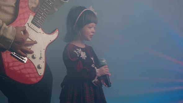 Little Girl in Vintage Dress Sings on Stage Her Father Plays an Electric Guitar