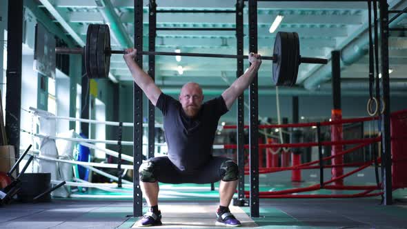 Wide Shot Muscular Powerlifter Lifting Barbell in Slow Motion in Gym Indoors alt
