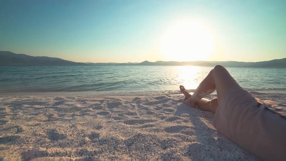 A Female Model is Sunbathing on the White Beach of the Tropical Sea, Lying Down on the Sand alt