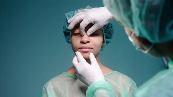 Surgeon Examines Girl's Face Before Rhinoplasty Wearing Protective Gloves