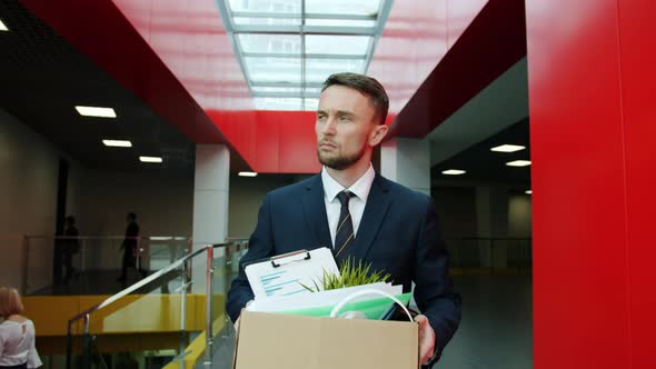 Fired Clerk Unhappy Young Man in Suit Walking in Hall Leaving Workplace with Box of Belongings alt