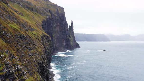 Aerial View High Rock Cliffs Ocean Waves Break on Cliffs alt