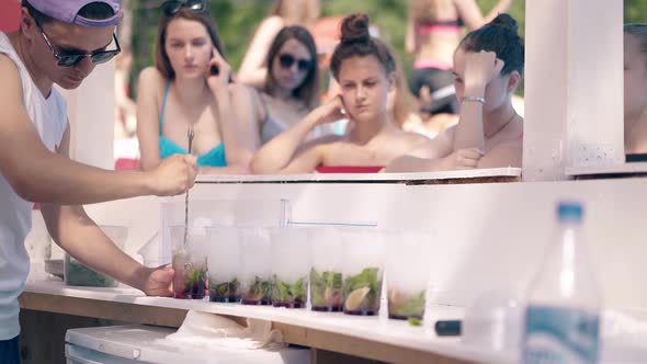 Young Girls Stand Near Bar on Beach Waiting for Bartender alt