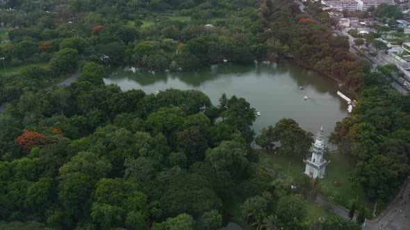 Green Park in Metropolitan City. Drone View of Green Trees of Lumphini Park Near Road and High Rise alt