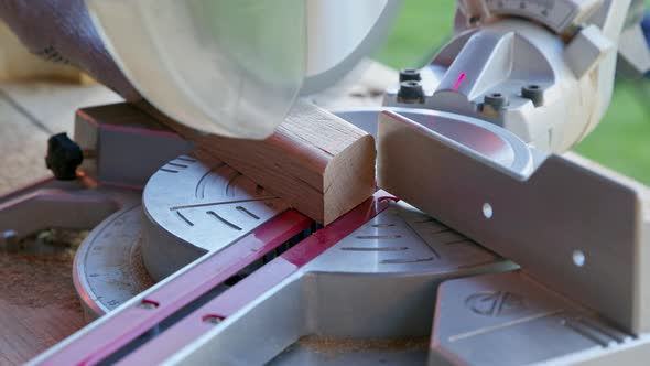 Woodworker Cuts Oak Workpiece on Mitre Saw Diagonally Angle 30 Degrees Close-up alt