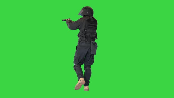 Armed Police Officer Aiming and Shooting with a Pistol While Walking on a Green Screen Chroma Key alt