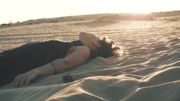 Woman Lying on the Sand at Sunset