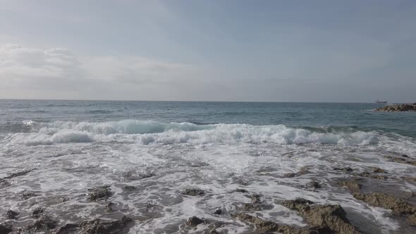 Mediterranean seaside beach view with waves and foam