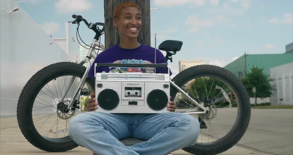 Dolly shot of attractive young African American women with boom box on lap alt