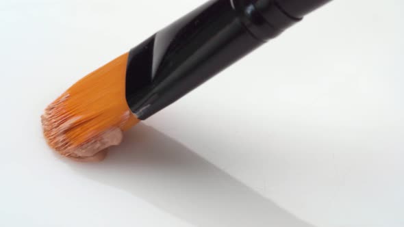 Facial Foundation Smudge Made with a Brush on White Makeup Palette Close Up alt