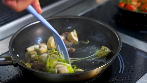 Mushrooms fried with vegetablesin a big frying pan.  alt