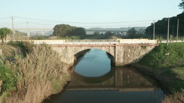 Reflections Through Calm River With Stone Arch Bridge During Daytime At Alcobaca River Near Nazare I alt